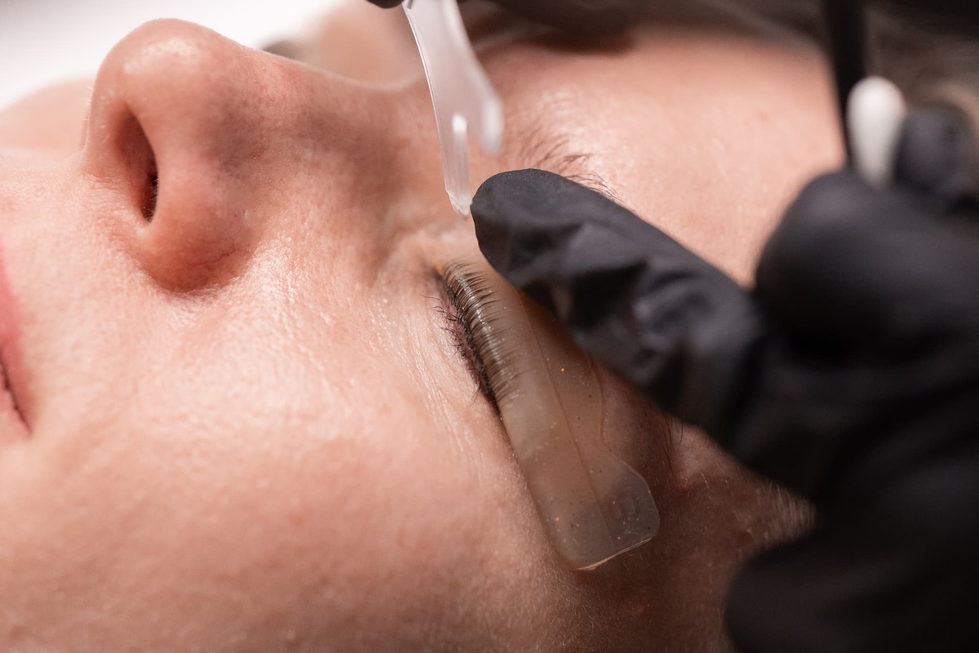Lifting i laminacja rzęs w Białymstoku — zbliżenie na uniesione rzęsy podczas zabiegu w SKiN